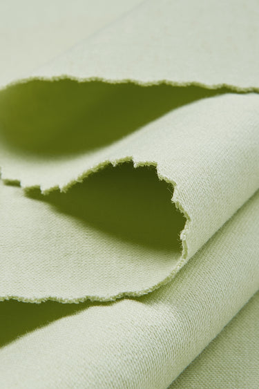 Cotton interlock knit fabric close-up with edge structure detail and soft hand feel for modern casualwear and everyday apparel.