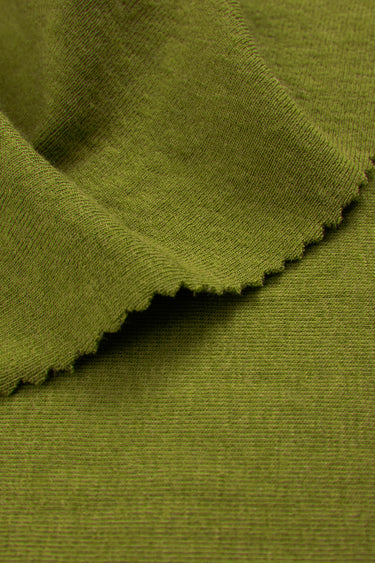 Mousse acrylic cashmere rib knit fabric close-up with folded edge detail and soft fleece texture for comfortable knit garments.
