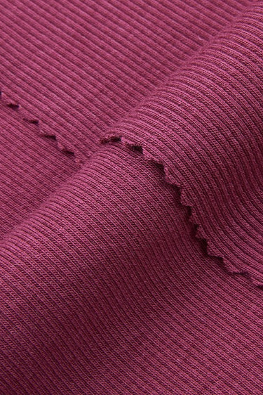 Cotton modal spandex stretch rib knit fabric close-up with edge structure detail and soft dry touch for base layers and casualwear.