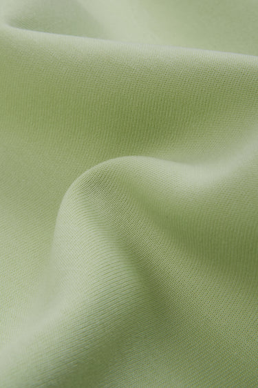 Cotton polyester interlock knit fabric close-up with surface drape detail and smooth hand feel for structured knit garments.