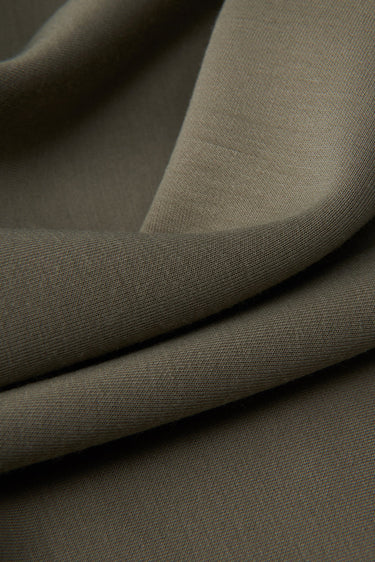 Jelly air-layer SCUBA knit fabric close-up with surface drape detail and structured comfort for everyday garments.