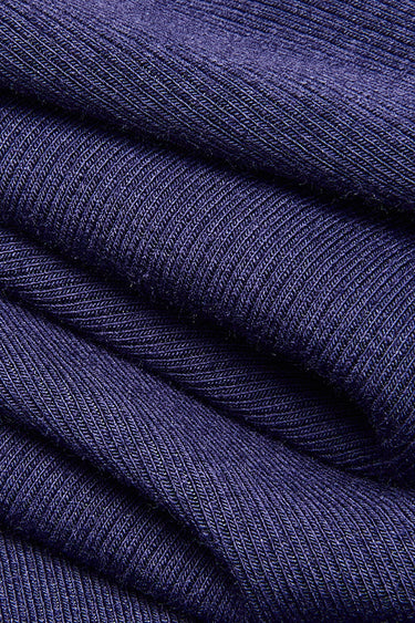 Viscose cotton spandex stretch rib knit fabric close-up with folded drape detail and soft hand feel for long-term garment programs.