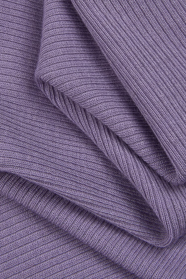 Merino wool elastane double-face rib knit fabric close-up with folded drape detail and structured rib texture for transitional knitwear.