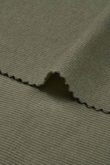 Mousse cashmere warm stretch rib knit fabric close-up with surface edge detail and comfortable stretch for modern knitwear.