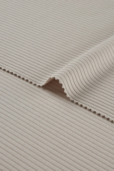 Viscose nylon spandex rib knit fabric close-up with edge structure detail and deep rib channels for fitted garments.