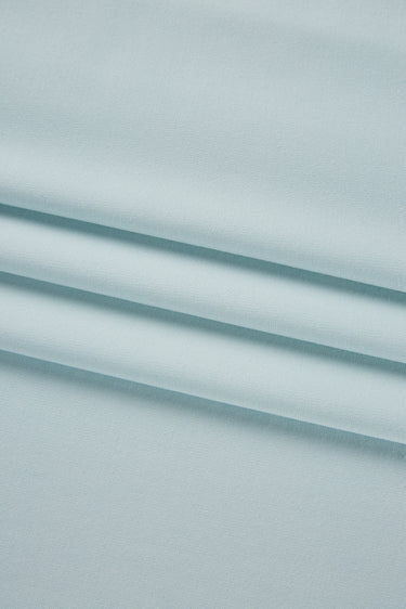 Stretch double knit base fabric close-up with surface fold detail and clean texture for modern knit garments.