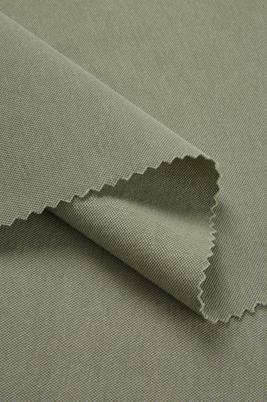 Quick-drying piqué knit fabric close-up with folded edge detail and soft dry touch for comfortable everyday apparel.