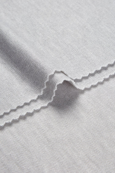 TENCEL wool blend interlock fabric close-up with edge structure detail and smooth hand feel for comfortable base layers.
