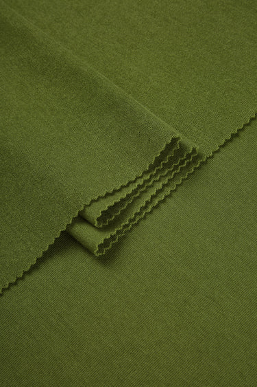 Merino cashmere blend mousse knit fabric close-up with folded edge detail and smooth hand feel for comfortable knit garments.