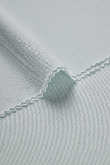 Mousse rib knit fabric close-up with edge structure detail and soft micro-fleece surface for casualwear.