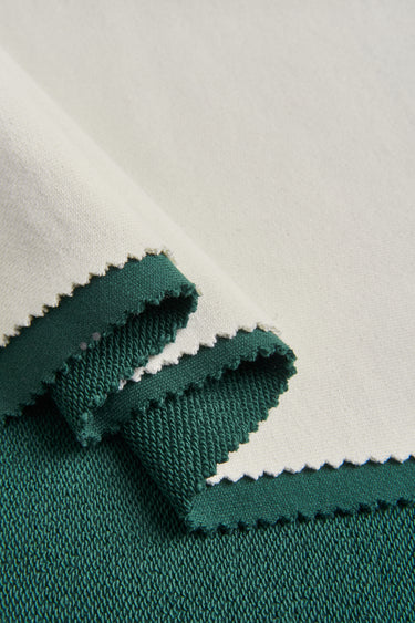 TENCEL linen blend single jersey fabric close-up with folded edge detail and natural dry texture for lightweight tops and summer knitwear.