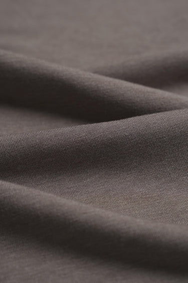 Grey taupe cashmere wool blend knit fabric close-up with fine rib texture and soft drape for luxury knitwear.
