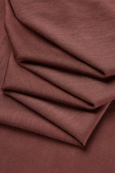 Lenzing TENCEL Lyocell single jersey fabric close-up with folded drape detail for lightweight summer apparel and soft everyday wear.