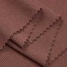 Viscose spandex stretch rib knit fabric close-up with layered fold detail and high elasticity for fitted knitwear and rib trims.