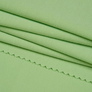 Long staple cotton double knit fabric close-up with folded drape detail for warmer-season knitwear and everyday apparel.