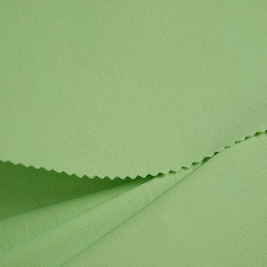 Long staple cotton double knit fabric close-up with folded edge detail and natural cotton softness for breathable casualwear.