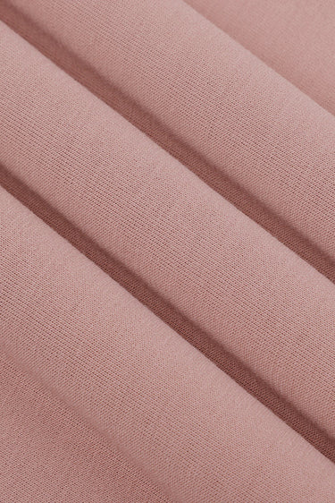 Viscose-covered filament single jersey fabric close-up with folded drape detail and smooth surface for everyday knitwear.