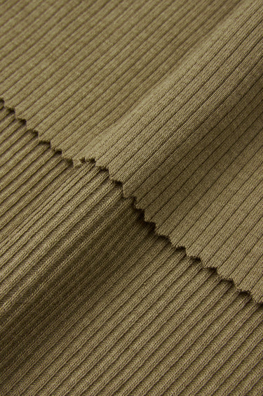 Cotton viscose spandex rib knit fabric close-up with edge structure detail for flexible garments and close-fitting apparel.