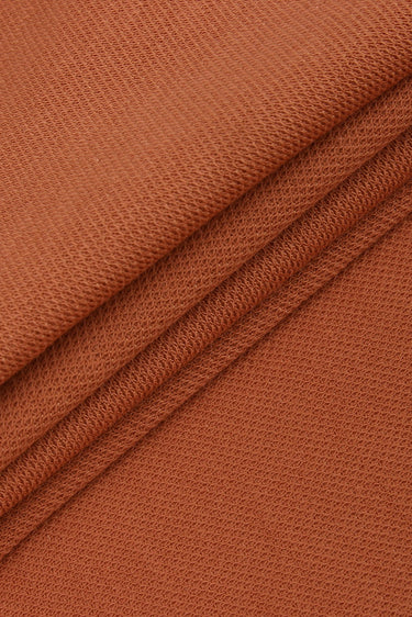 Cotton double piqué knit fabric close-up with surface fold detail and soft hand feel for polo shirts and everyday casualwear.