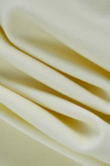 Double-sided piqué knit fabric close-up with folded drape detail and breathable texture for casualwear and knit apparel.