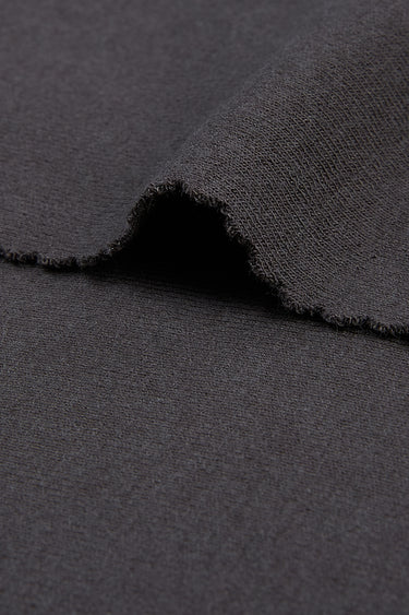 Mousse acrylic cashmere rib knit fabric close-up with edge structure detail and smooth hand feel for comfortable knit garments.