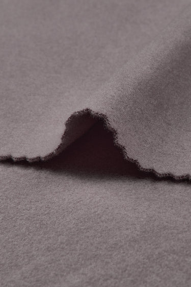Double-sided stretch knit fabric close-up with edge structure detail for layering garments and knitwear.