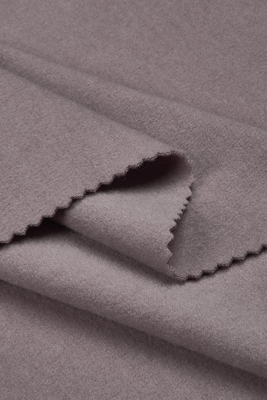 Double-sided stretch knit fabric close-up with folded edge detail for comfortable layering garments.