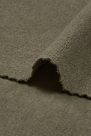 Cotton polyester terry knit fabric close-up with edge structure detail and looped inner surface for breathable comfort.