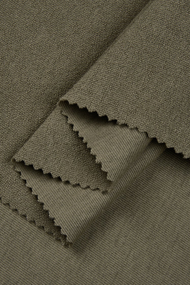 Cotton polyester terry knit fabric close-up with layered fold detail for comfortable everyday apparel.