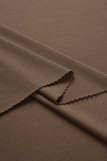 Rayon nylon blend stretch rib knit fabric close-up with layered fold detail for close-fitting apparel and comfortable knitwear.