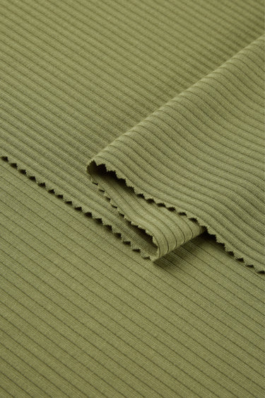 Viscose nylon spandex rib knit fabric close-up with folded edge detail and high-stretch texture for modern knit apparel.