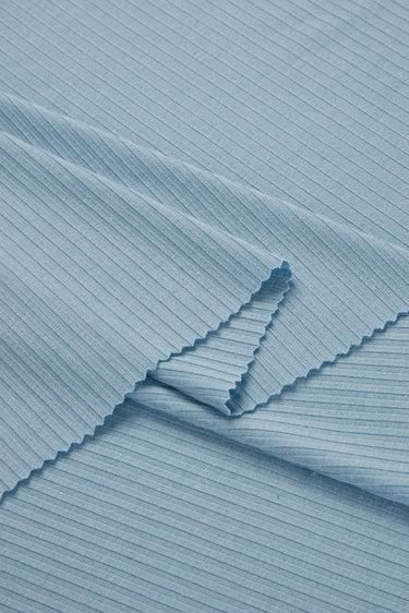 Viscose nylon spandex rib knit fabric close-up with layered fold detail and flexible stretch recovery for modern knit apparel.