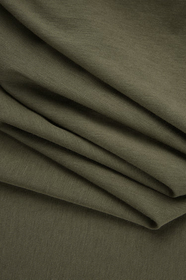 Cotton blend stretch single jersey fabric close-up with folded drape detail for underwear and soft casual garments.