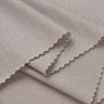 Lenzing TENCEL stretch single jersey fabric close-up with folded edge detail and soft dry touch for warm-weather garments.