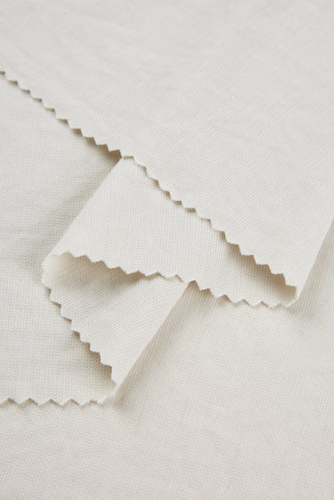 Sand-washed Lenzing modal stretch double knit fabric close-up with layered edge detail and matte texture for refined everyday garments.