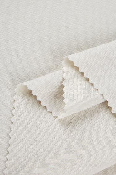 Sand-washed Lenzing modal stretch double knit fabric close-up with layered fold detail and smooth hand feel for modern knitwear.