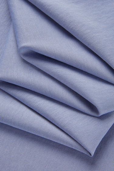 Cotton polyester stretch double knit base fabric close-up with folded drape detail for comfortable layering garments and everyday wear.