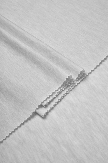 TENCEL wool blend stretch single jersey fabric close-up with folded edge detail for breathable base layers and everyday knitwear.