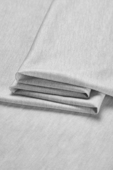 TENCEL wool blend stretch single jersey fabric close-up with folded stack detail for lightweight base layers and soft knit garments.