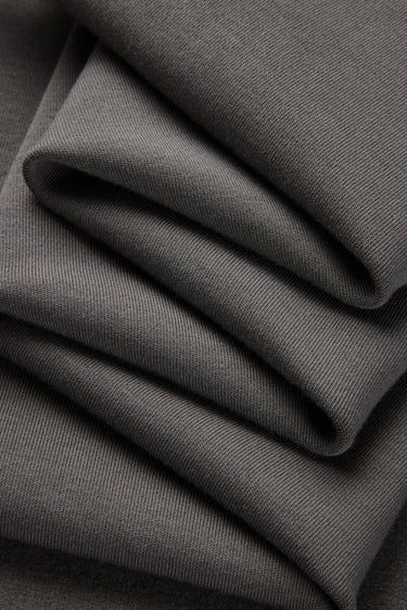 Mousse rib knit fabric close-up with folded drape detail and smooth hand feel for soft knit garments.