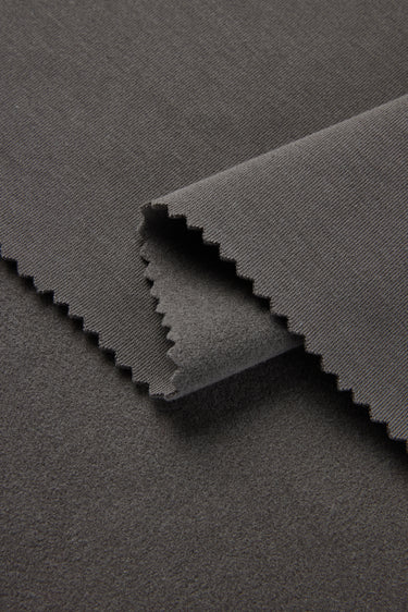 Mousse rib knit fabric close-up with folded edge detail for modern casualwear and comfortable knit garments.