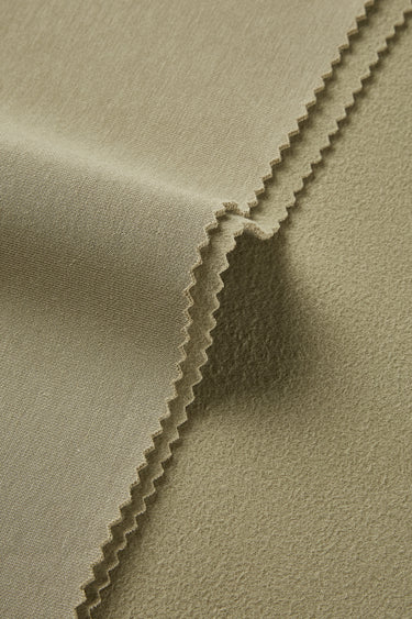 HEAT-FLOW fleece knit fabric close-up with edge structure detail for thermal tops and sweatshirts.