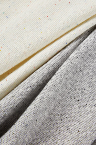 Mousse rib knit fabric close-up with surface fold detail and soft micro-fleece texture for modern casualwear.