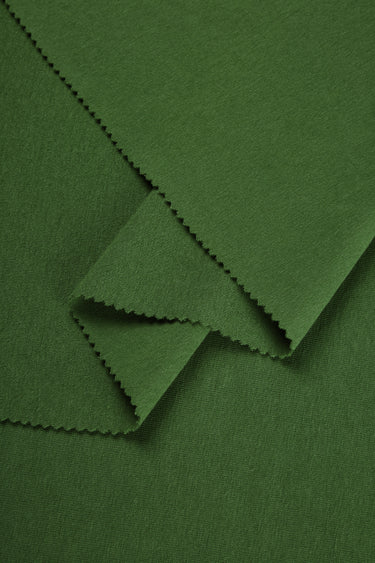 Merino wool blend mousse knit fabric close-up with layered fold detail for casualwear and soft knit garments.