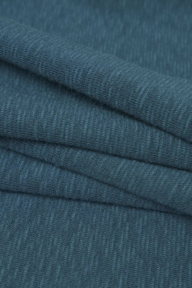 Bamboo slub mousse knit fabric close-up with folded drape detail for modern casualwear and soft knit garments.