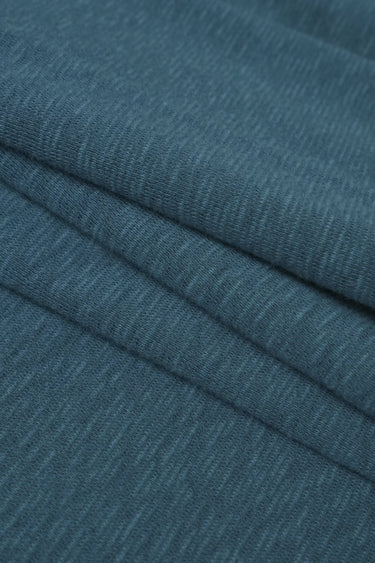 Bamboo slub mousse knit fabric close-up with layered fold detail and soft texture for casual knitwear.