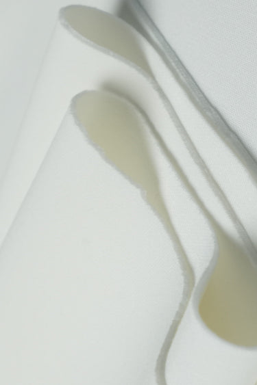 Sand-washed scuba interlock fabric close-up with layered fold detail for modern knitwear and durable everyday garments.