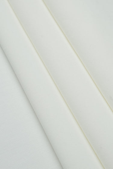 Sand-washed interlock fleece knit fabric close-up with surface fold detail and matte texture for modern knitwear and casual garments.