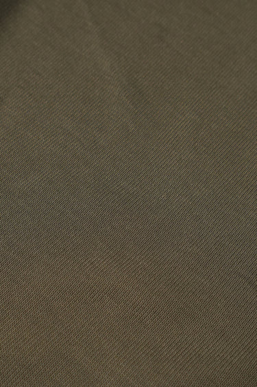 Sand-washed rib knit fabric close-up with smooth matte texture for modern knitwear and casual garments.