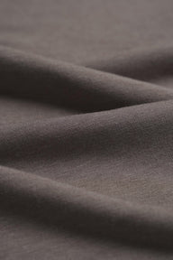 Grey taupe cashmere wool blend knit fabric close-up with fine rib texture and soft drape for luxury knitwear.